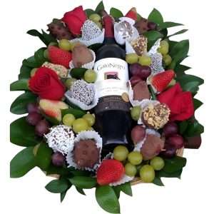 Arreglo de fresas, uvas, vino y rosas